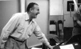 Man laughing near a piano