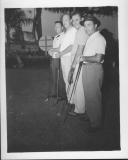 Four men posing with golf clubs